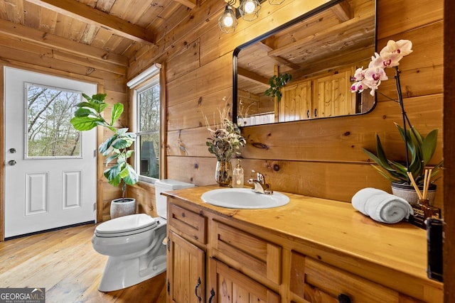 bathroom featuring hardwood / wood-style floors, beam ceiling, wood ceiling, and wood walls