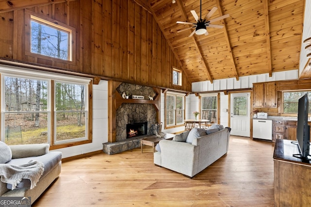 living room featuring a stone fireplace, wooden ceiling, light wood-style floors, and ceiling fan