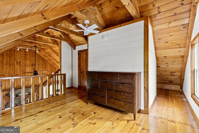 bonus room with wooden walls and a ceiling fan