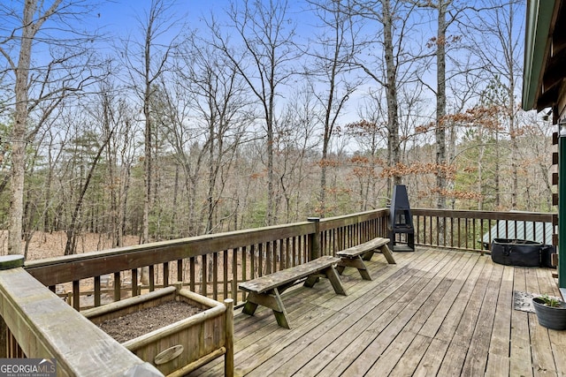 wooden terrace featuring a wooded view