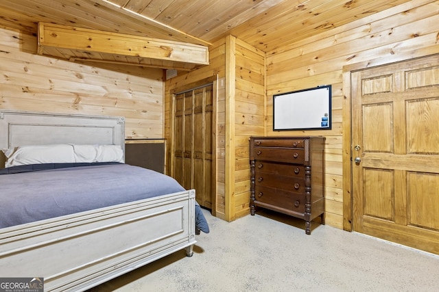 bedroom with a closet, wooden walls, wooden ceiling, and carpet