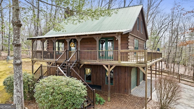 view of front of home featuring stairway, log siding, and metal roof