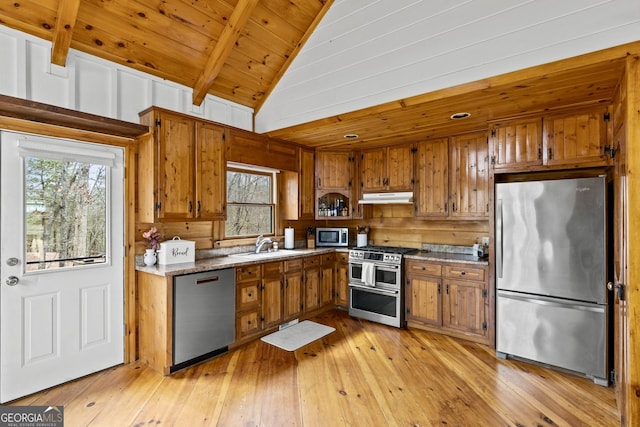 kitchen with brown cabinetry, wooden ceiling, appliances with stainless steel finishes, and lofted ceiling with beams