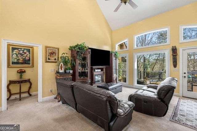 living room with ceiling fan, baseboards, carpet floors, and high vaulted ceiling
