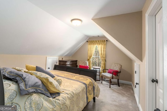 carpeted bedroom with baseboards and vaulted ceiling