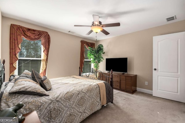 bedroom with a ceiling fan, baseboards, visible vents, and light carpet