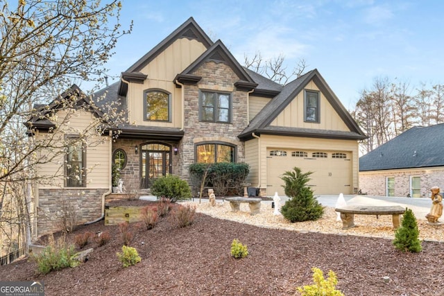 craftsman-style house featuring driveway, stone siding, roof with shingles, board and batten siding, and a garage