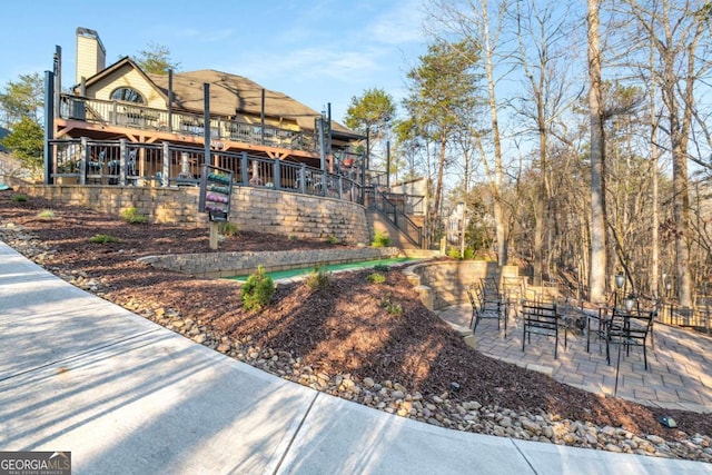 back of house featuring a patio, stairway, and a chimney