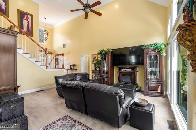 living area with a wealth of natural light, a high ceiling, and carpet floors