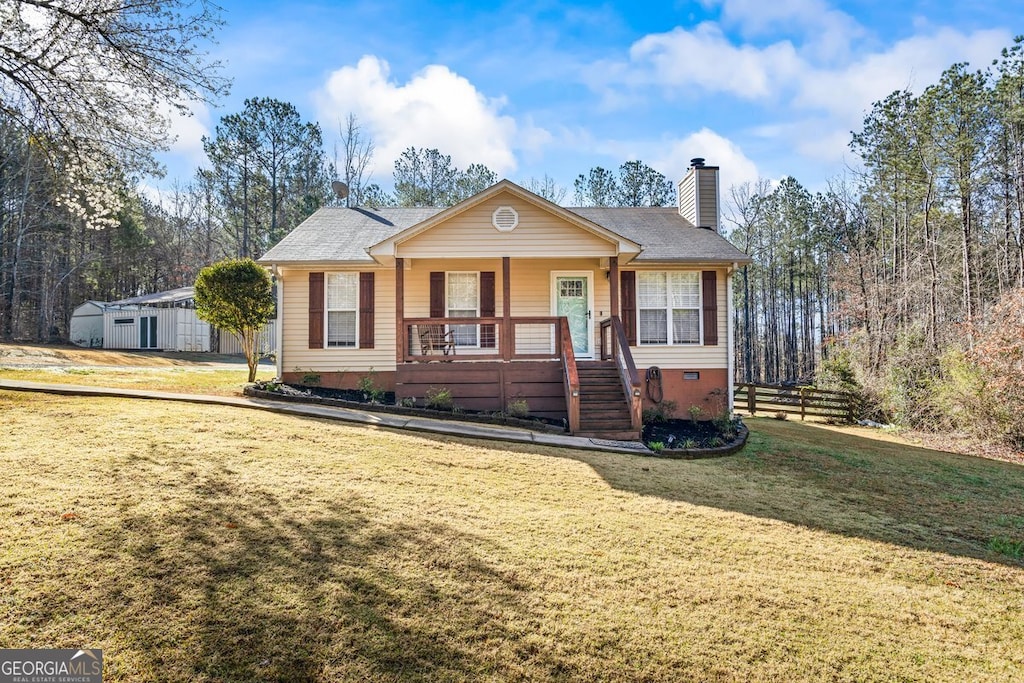 view of front of property with a porch, fence, a front yard, and a chimney