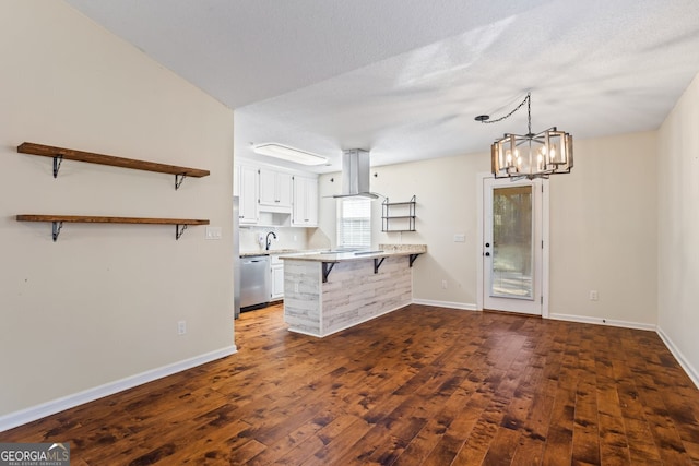 kitchen featuring a breakfast bar, a peninsula, island exhaust hood, white cabinets, and dishwasher