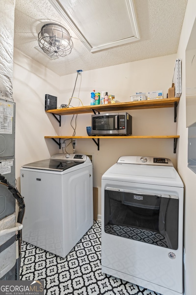 laundry area with washer and dryer, a textured ceiling, and laundry area