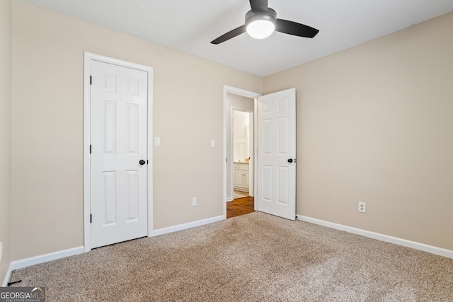 unfurnished bedroom with a ceiling fan, carpet, and baseboards