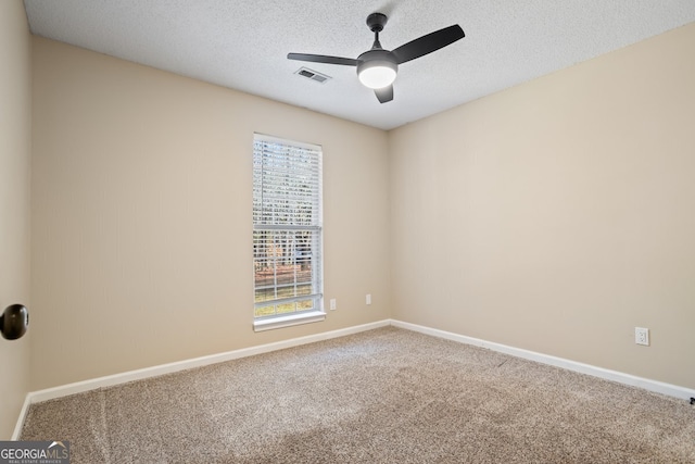 carpeted empty room with visible vents, baseboards, a textured ceiling, and a ceiling fan