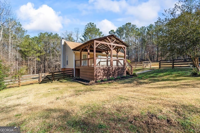 rear view of property with a gazebo, a yard, and fence