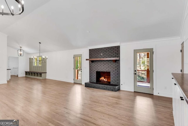 unfurnished living room featuring a brick fireplace, light wood-type flooring, and ornamental molding