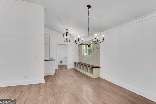 unfurnished dining area with light wood-style flooring, an inviting chandelier, baseboards, and vaulted ceiling