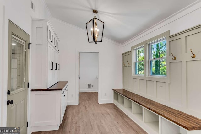 mudroom with visible vents, baseboards, a chandelier, ornamental molding, and light wood-style flooring