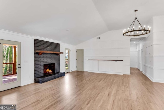 unfurnished living room with light wood-type flooring, visible vents, a fireplace, and vaulted ceiling