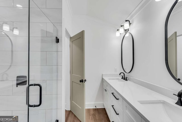 bathroom with wood finished floors, a stall shower, and a sink