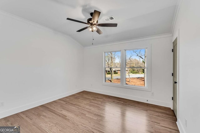 unfurnished room featuring visible vents, a ceiling fan, wood finished floors, crown molding, and baseboards