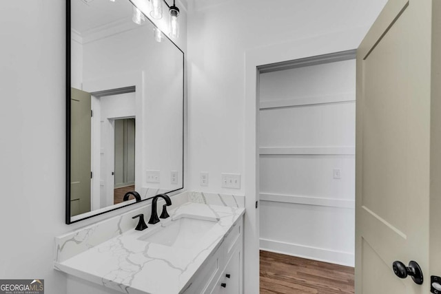 bathroom with vanity, wood finished floors, and baseboards