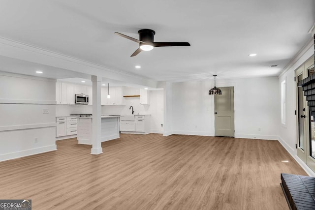 unfurnished living room with a ceiling fan, a sink, recessed lighting, light wood-style floors, and baseboards