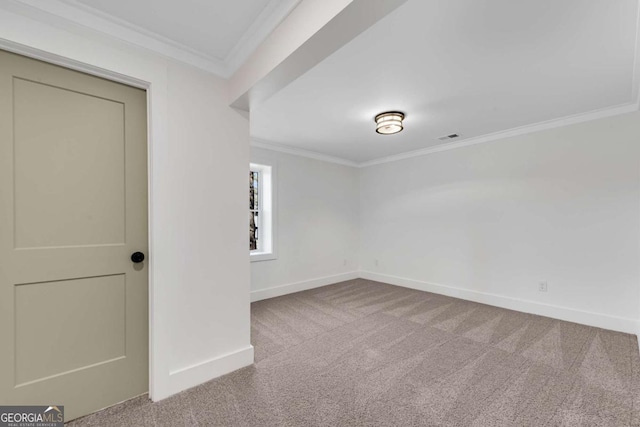 carpeted empty room featuring crown molding, visible vents, and baseboards