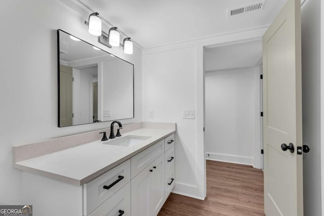 bathroom with visible vents, baseboards, wood finished floors, and vanity