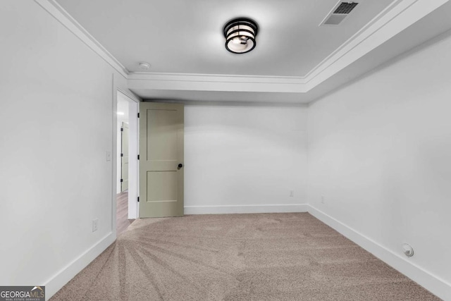 empty room with visible vents, crown molding, and baseboards