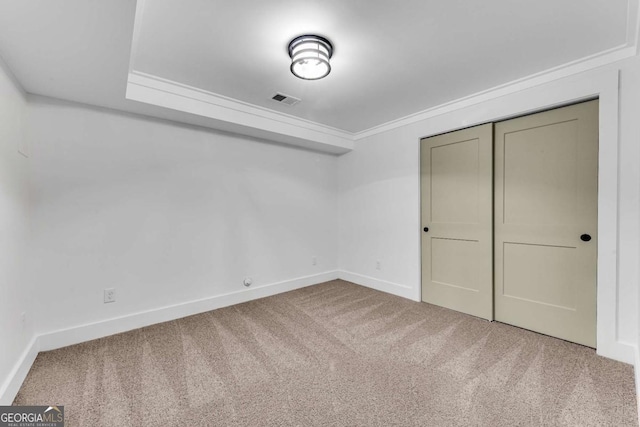 unfurnished bedroom with visible vents, baseboards, carpet, and crown molding