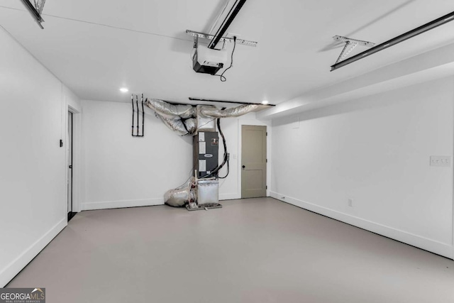 garage featuring a garage door opener and baseboards