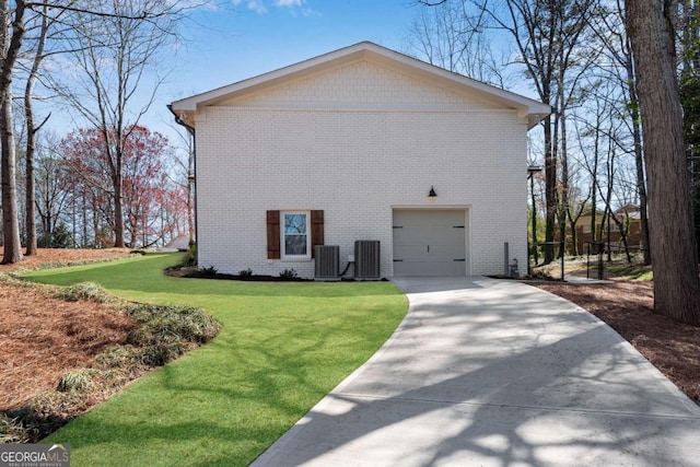 view of home's exterior featuring central air condition unit, a garage, a lawn, and brick siding