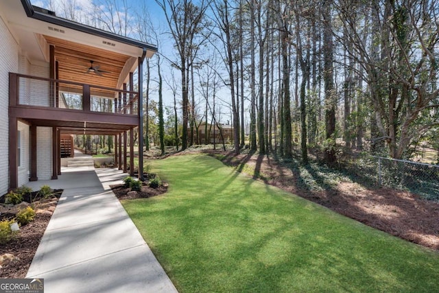 view of yard with stairway, fence, and ceiling fan