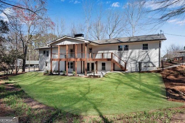 rear view of property featuring a lawn, fence, french doors, brick siding, and a chimney