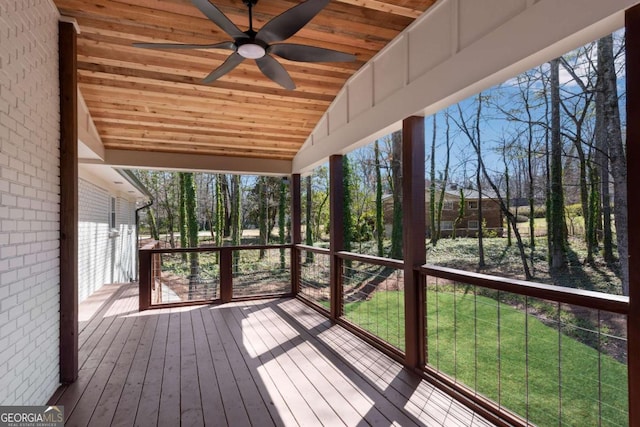 wooden deck with a lawn and ceiling fan