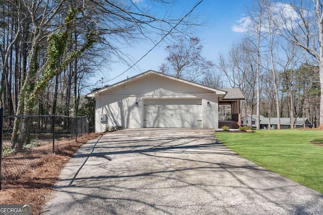 view of home's exterior featuring aphalt driveway, a lawn, a garage, and brick siding