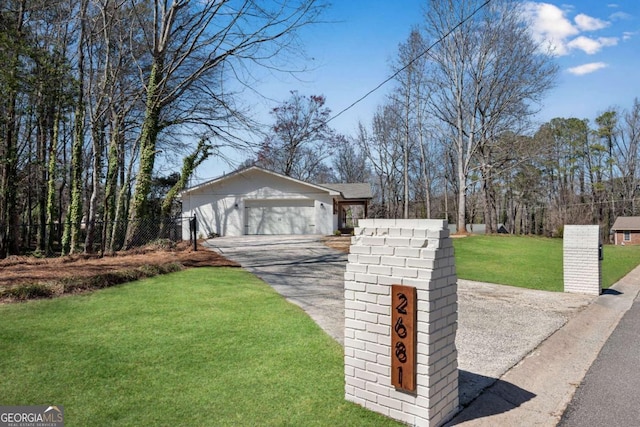 view of front of home featuring a garage, driveway, a front yard, and fence