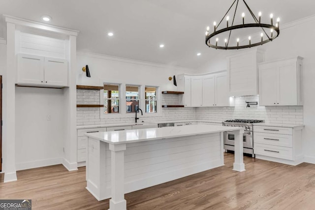 kitchen featuring double oven range, light countertops, ornamental molding, white cabinetry, and open shelves