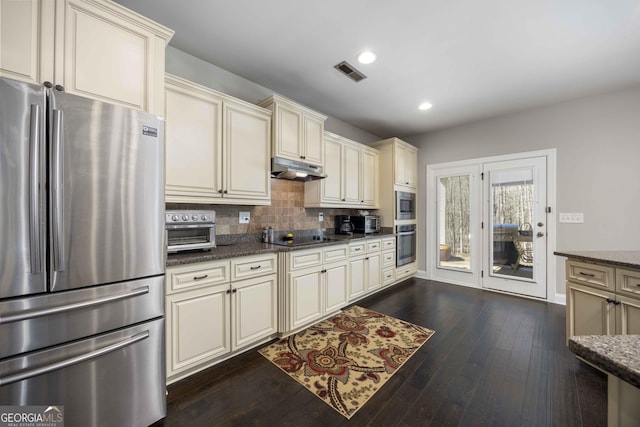 kitchen featuring under cabinet range hood, visible vents, cream cabinets, and appliances with stainless steel finishes