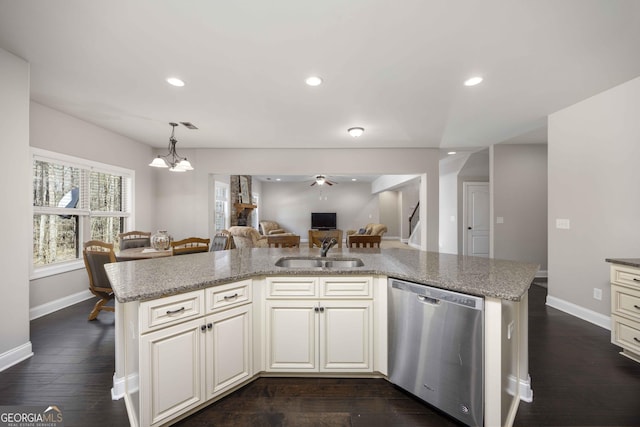 kitchen with stainless steel dishwasher, recessed lighting, open floor plan, and a sink