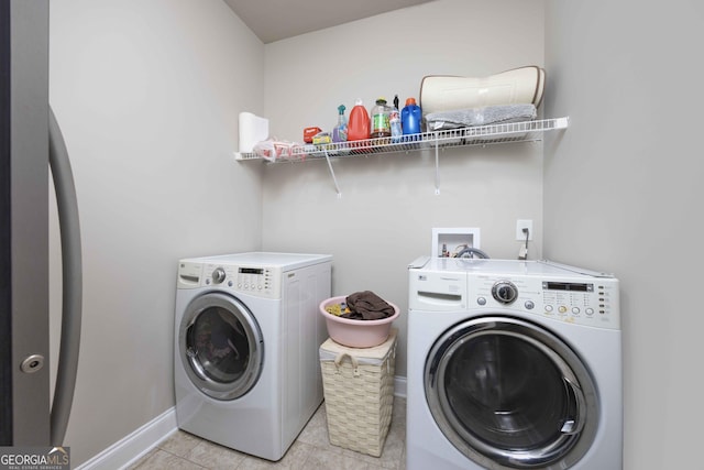 laundry room featuring light tile patterned floors, baseboards, washing machine and dryer, and laundry area