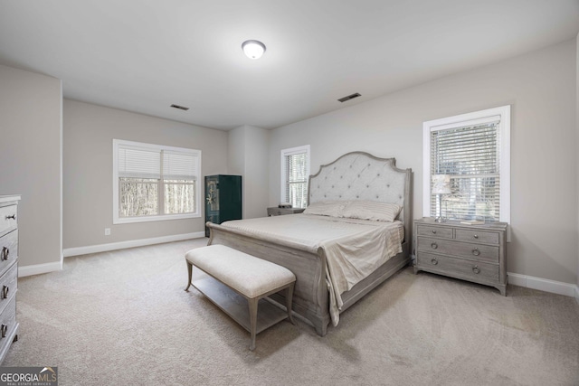 bedroom with visible vents, light colored carpet, and baseboards