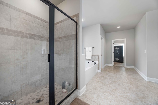 full bath with a bath, a stall shower, and baseboards