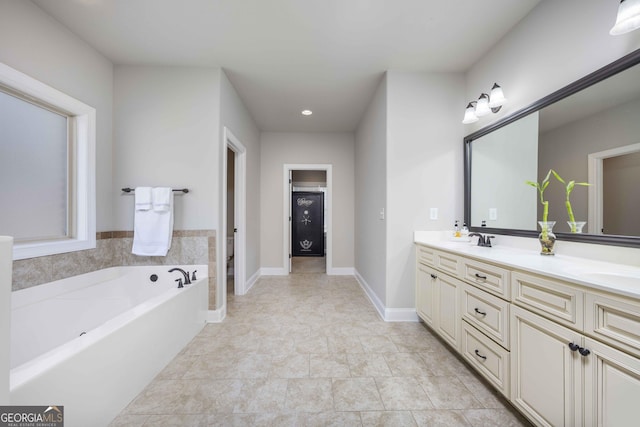 full bathroom with a garden tub, double vanity, baseboards, and a sink