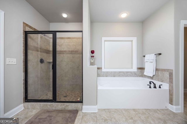 full bath with tile patterned floors, a bath, and a stall shower