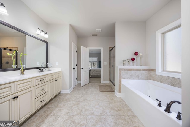 ensuite bathroom with a shower stall, baseboards, a garden tub, double vanity, and ensuite bathroom