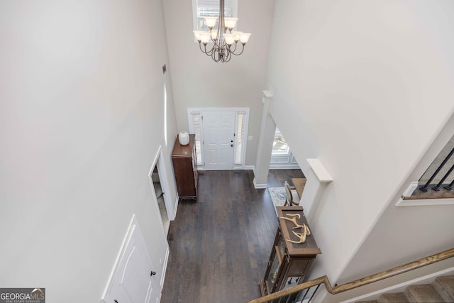 entrance foyer with stairway, wood finished floors, a chandelier, and a towering ceiling