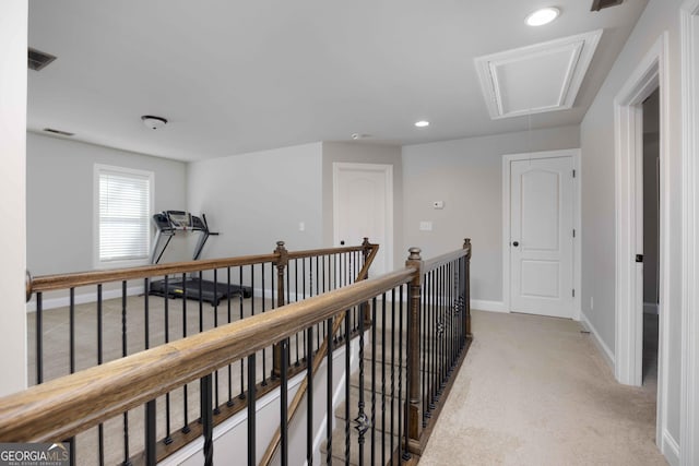 corridor with visible vents, an upstairs landing, baseboards, light colored carpet, and attic access