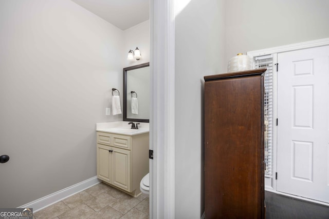 bathroom with tile patterned floors, baseboards, toilet, and vanity